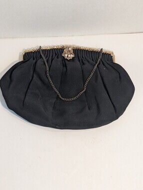 A Vintage evening bag features a black fabric design.